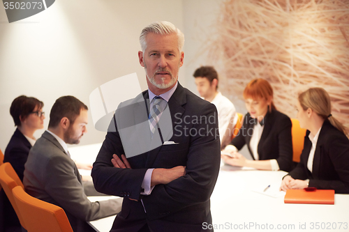 Image of senior business man with his team at office