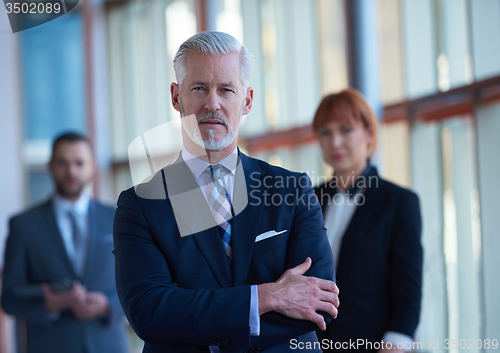 Image of senior business man with his team at office