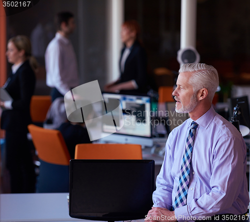 Image of senior business man with his team at office