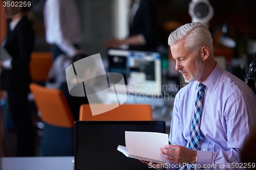 Image of senior business man with his team at office