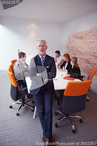 Image of senior business man with his team at office