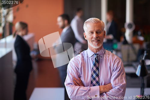 Image of senior business man with his team at office
