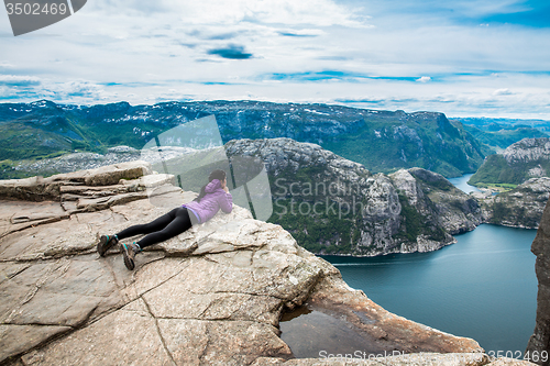 Image of Prekestolen. Woman looking at the landscape from a height.