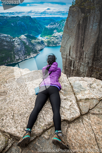 Image of Prekestolen. Woman looking at the landscape from a height.