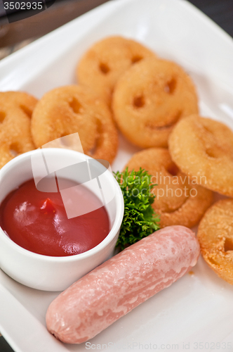 Image of sausages with smiling potatoes