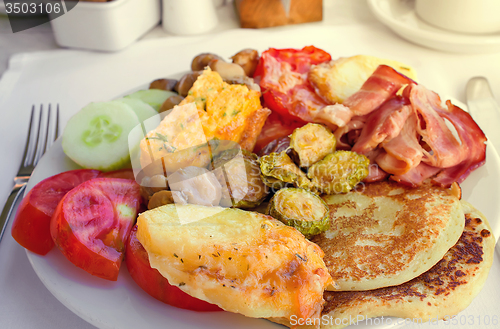 Image of Meat, fish and various vegetable garnish on a plate.