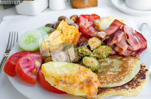 Image of Meat, fish and various vegetable garnish on a plate.