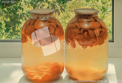 Image of Home canning: large glass cylinders with apricot compote.
