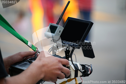 Image of Operator holding a remote control with helicopter drone