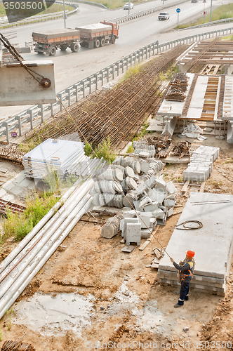 Image of Worker levels provision of plate lifting by crane