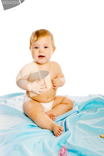 Image of baby in diaper sitting on a blue blanket. Isolated