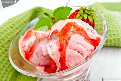 Image of Ice cream strawberry with syrup in glass on board