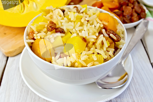 Image of Pilaf fruit with pumpkin in bowl and spoon on board