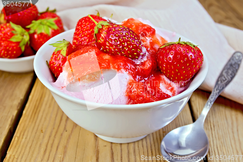 Image of Ice cream strawberry in white bowl and spoon on board