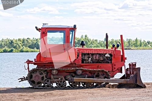 Image of Bulldozer red by the river