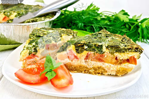 Image of Pie celtic with spinach and tomato in plate on table