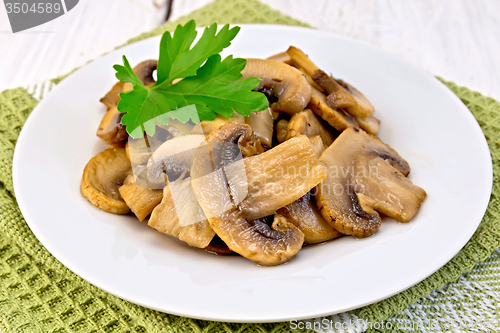 Image of Champignons fried in plate on light board