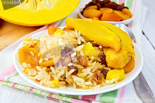 Image of Pilaf fruit with pumpkin in white plate on board