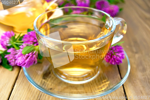 Image of Tea with clover in cup and teapot on board