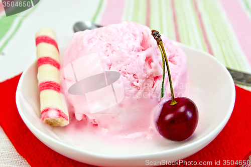 Image of Ice cream cherry on red paper napkin with waffles