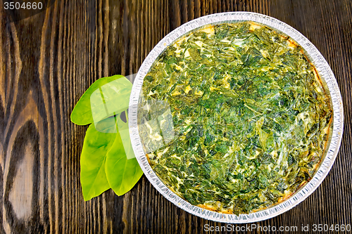 Image of Pie celtic with spinach in form of foil on board