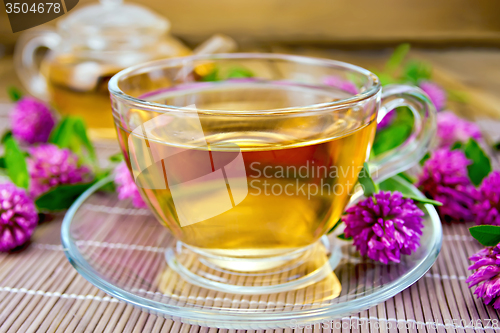 Image of Tea with clover in cup on bamboo