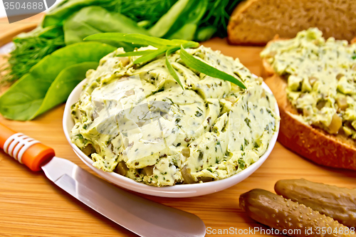 Image of Butter with spinach and herbs in bowl on board