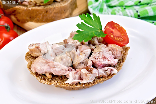 Image of Sandwich with brains and parsley in plate on board