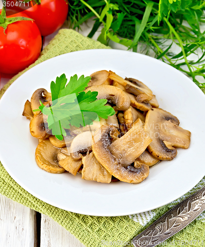 Image of Champignons fried in plate on napkin and board