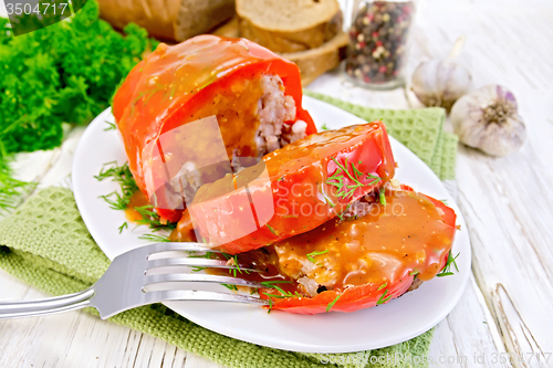 Image of Pepper stuffed meat with sauce and fork in plate on table