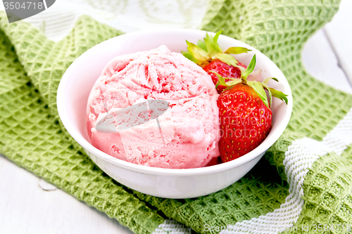 Image of Ice cream strawberry in bowl on board and napkin