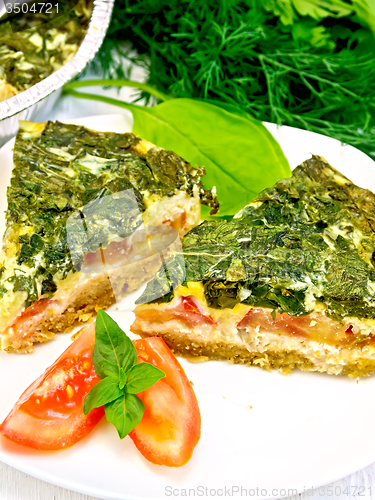 Image of Pie celtic with spinach and tomato in plate on board