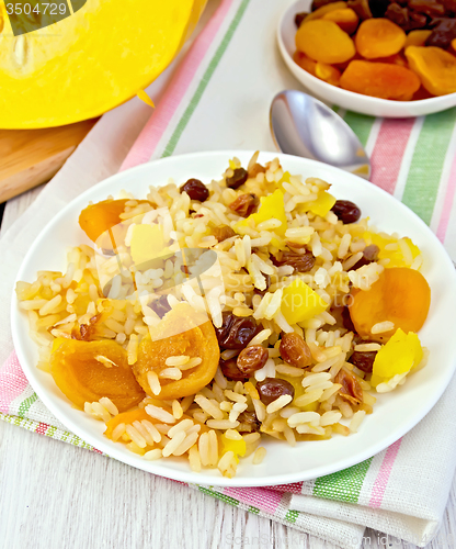 Image of Pilaf fruit with pumpkin in white plate on light board