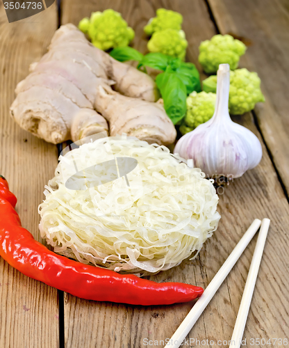 Image of Noodles rice twisted with spices and broccoli on board