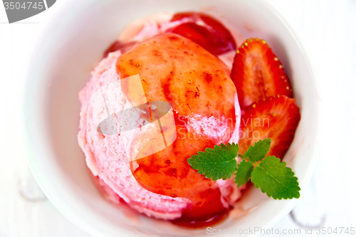 Image of Ice cream strawberry with syrup on board top