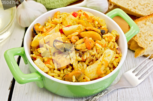 Image of Pilaf with seafood and fork on board