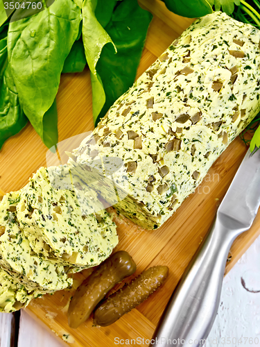 Image of Butter with spinach and cucumbers on wooden board