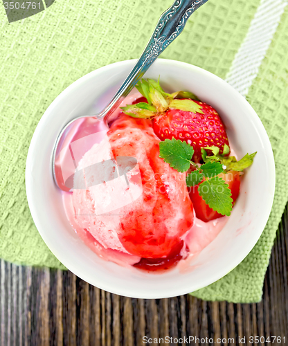 Image of Ice cream strawberry with syrup in bowl on board