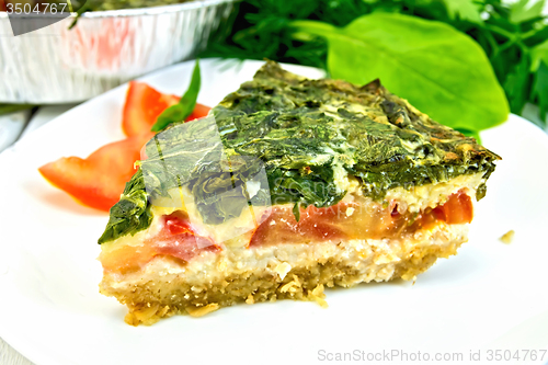 Image of Pie celtic with spinach in  white plate on table
