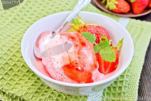 Image of Ice cream strawberry with syrup and spoon in bowl on board