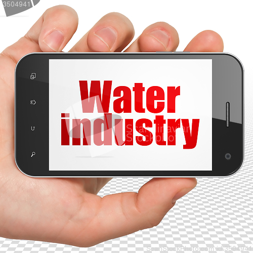 Image of Manufacuring concept: Hand Holding Smartphone with Water Industry on display