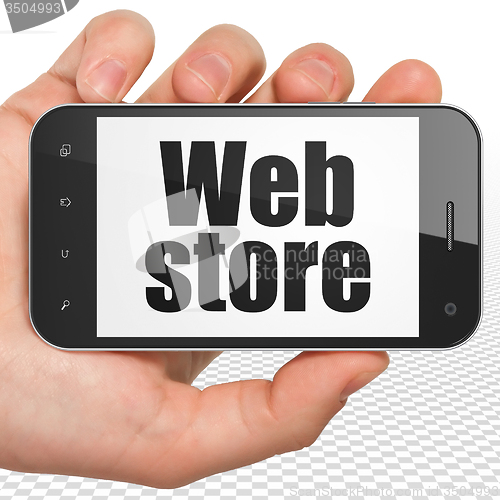 Image of Web design concept: Hand Holding Smartphone with Web Store on display