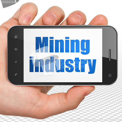 Image of Industry concept: Hand Holding Smartphone with Mining Industry on display