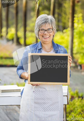 Image of Elderly woman in a green house