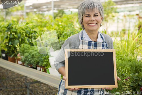 Image of Elderly woman in a green house