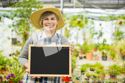 Image of Elderly woman in a green house