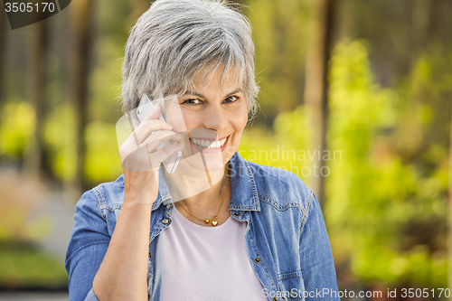 Image of Mature woman talking at phone