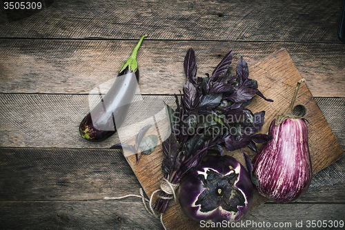 Image of Aubergines and basil on chopping board 