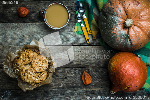 Image of Rustic style pumpkins soup and cookies with seeds on wood