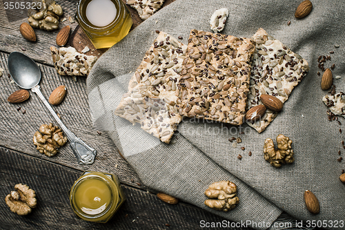 Image of dietic cookies with honey and nuts on rustic table